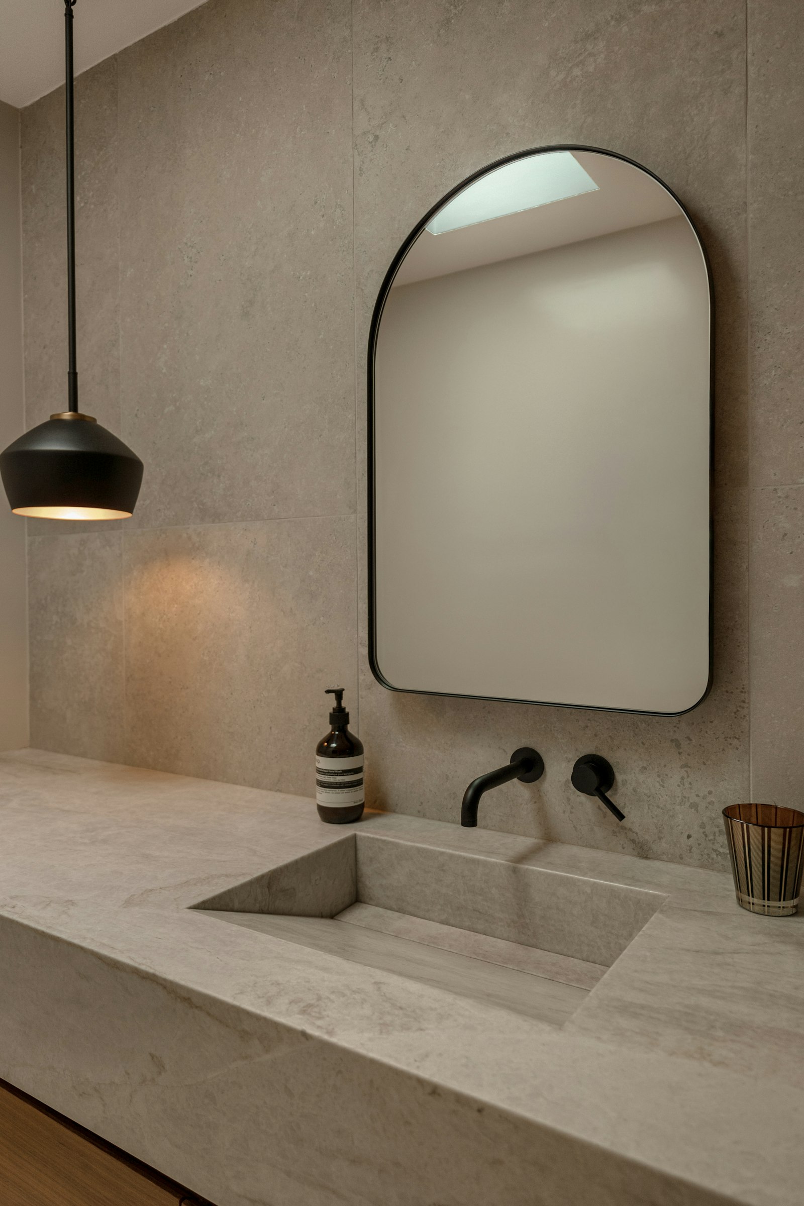 Arched mirror above a stone basin