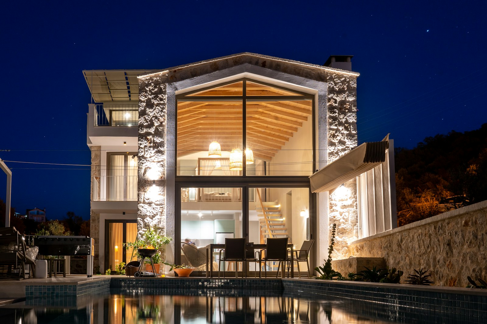 Glass-fronted house glowing at dusk